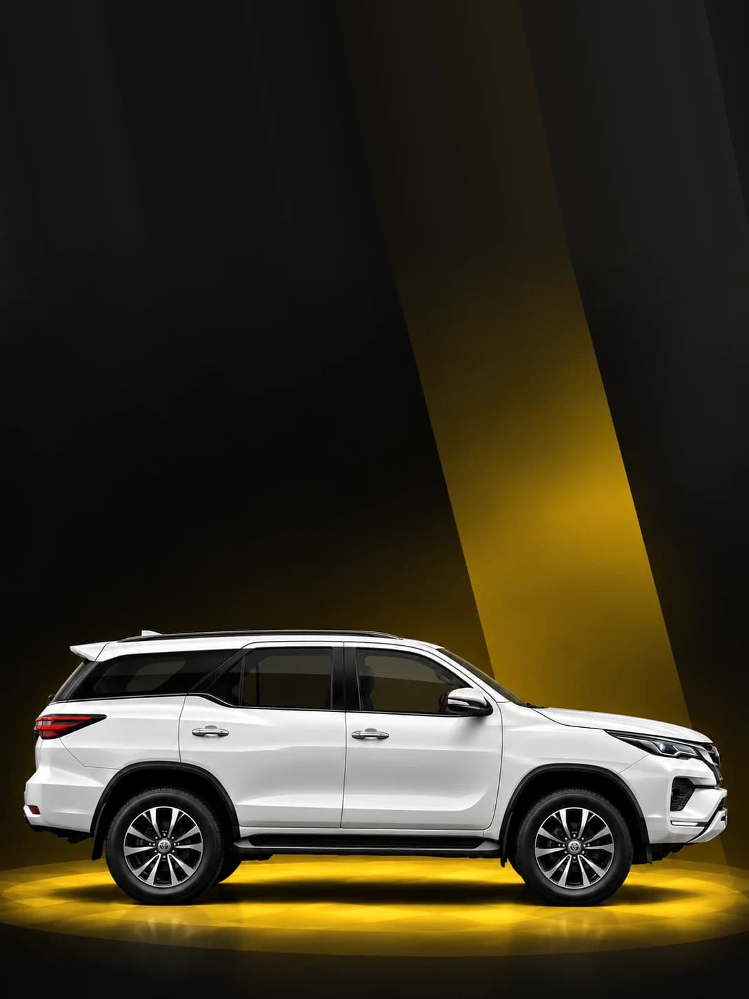 White Toyota Fortuner SUV under a yellow spotlight