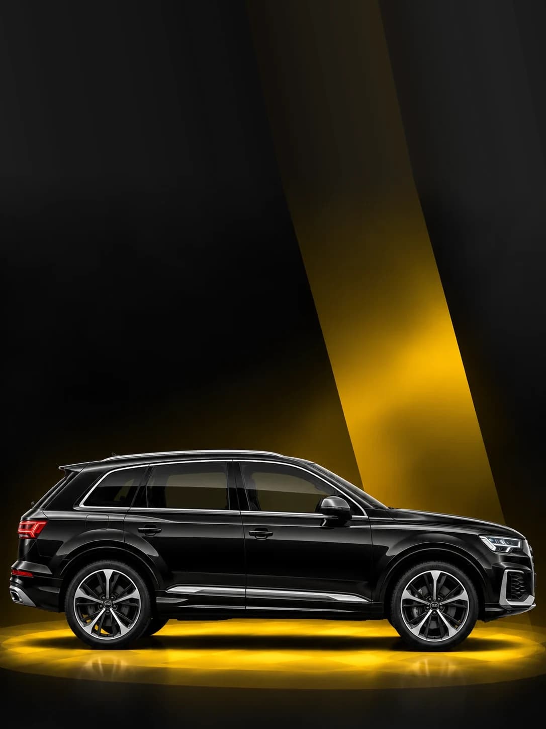 Black Audi Q7 SUV under a yellow spotlight